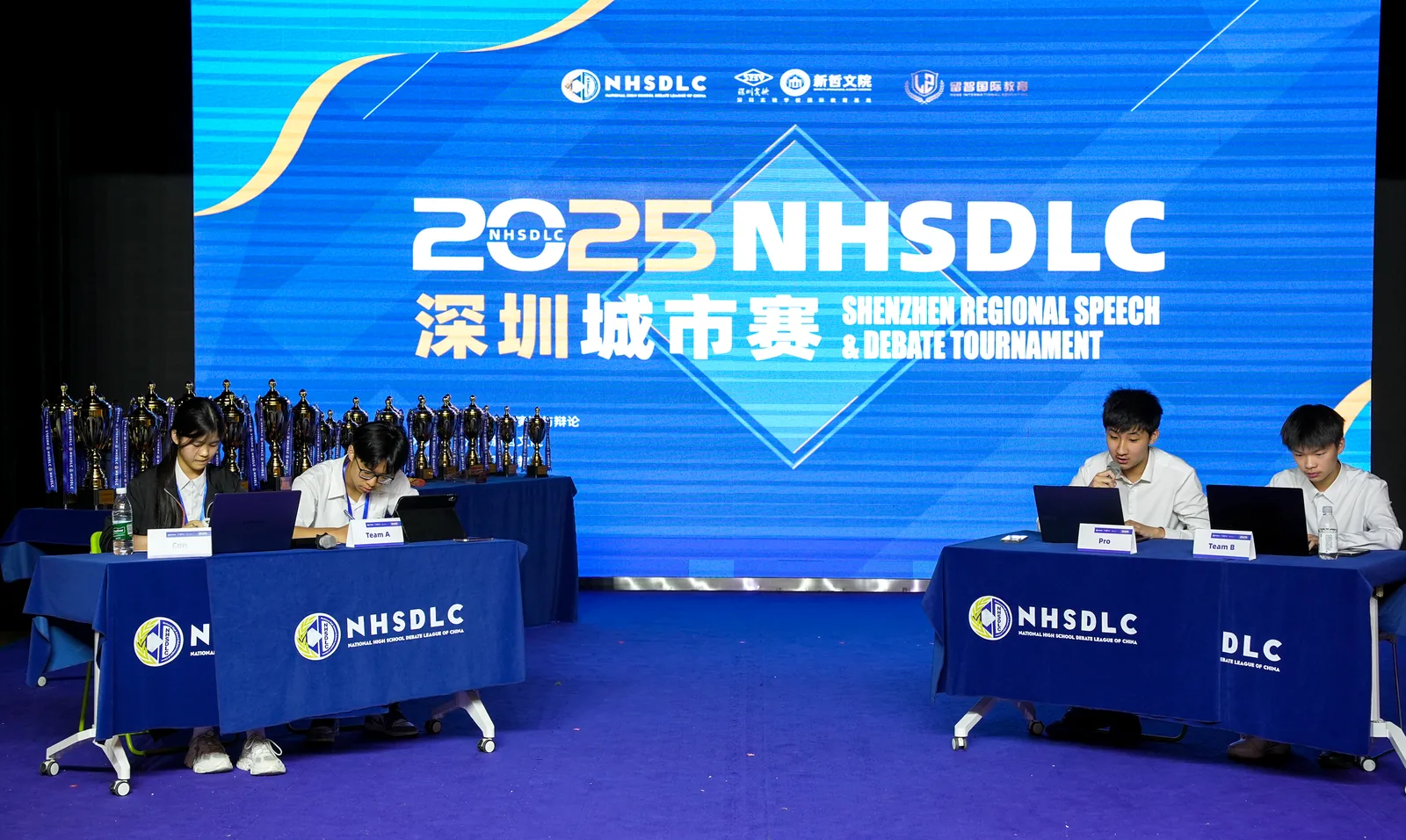 The 2025 NHSDLC Shenzhen regional debate tournament stage.