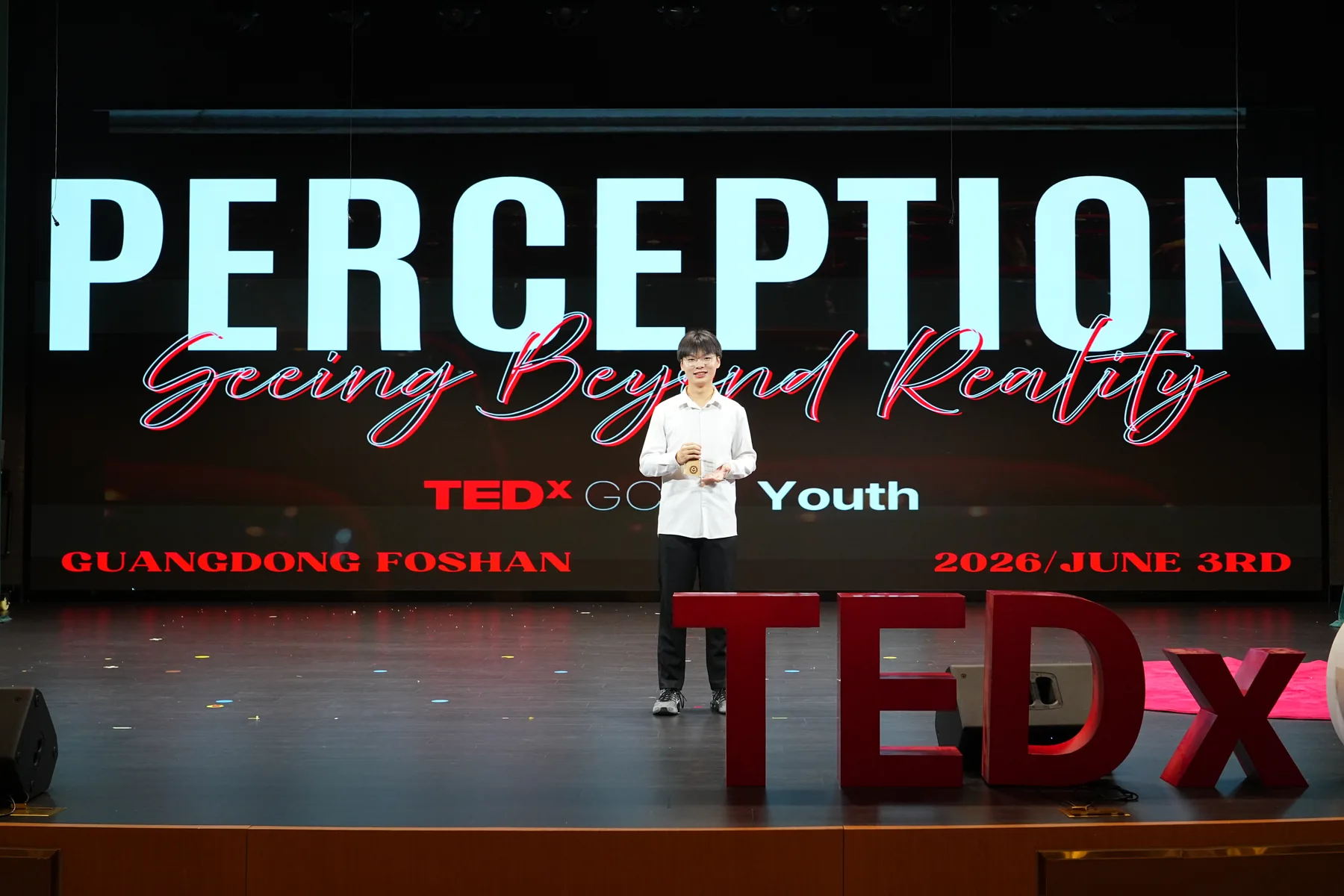 Jacky on the TEDx stage in front of a large PERCEPTION backdrop.